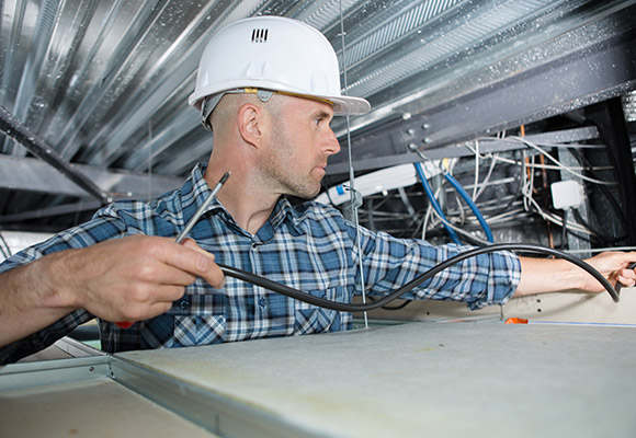 Man installing fire alarm systems in Hallandale Beach 